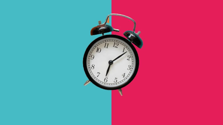 an old school clock with a blue and pink background